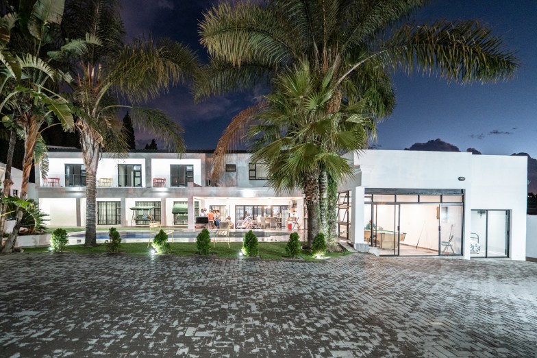 Double height white villa lit up at night
