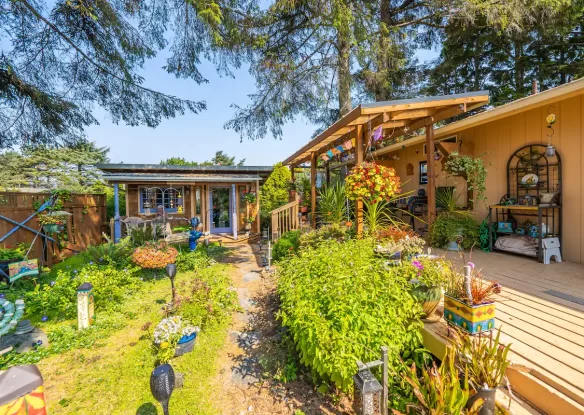 Artsy house with landscaping and raised deck