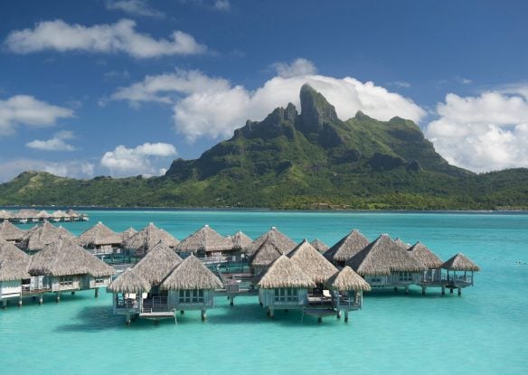Overwater bungalows with backdrop of mountain
