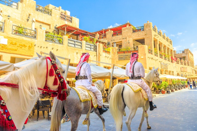 Heritage police officers in traditional 1940s Qatari uniforms at the old Souq Waqif