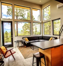 living room with floor-to-cieling windows in a forest