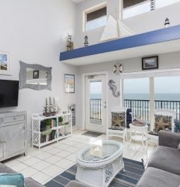 bright living room with windows overlooking ocean
