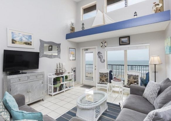 bright living room with windows overlooking ocean