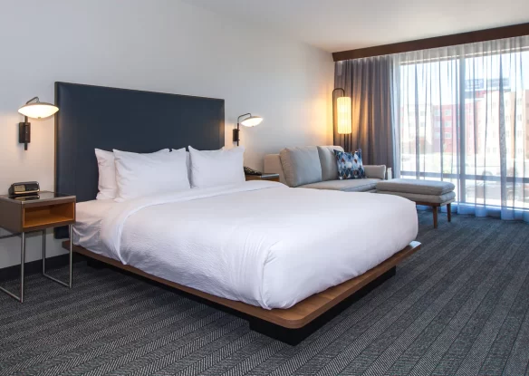 hotel room with bed and curtained windows